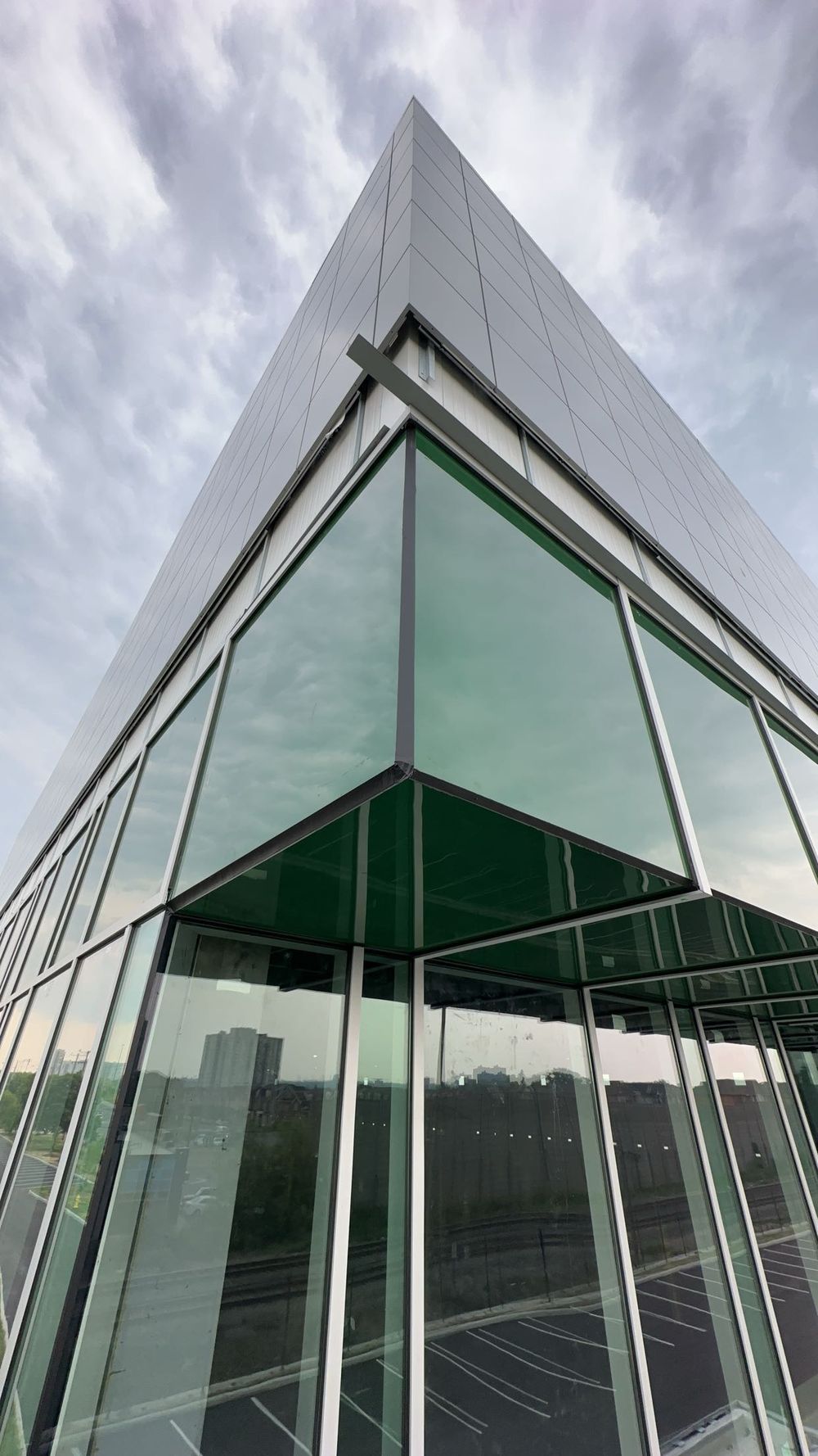 The glazed corner of a new building seen from below