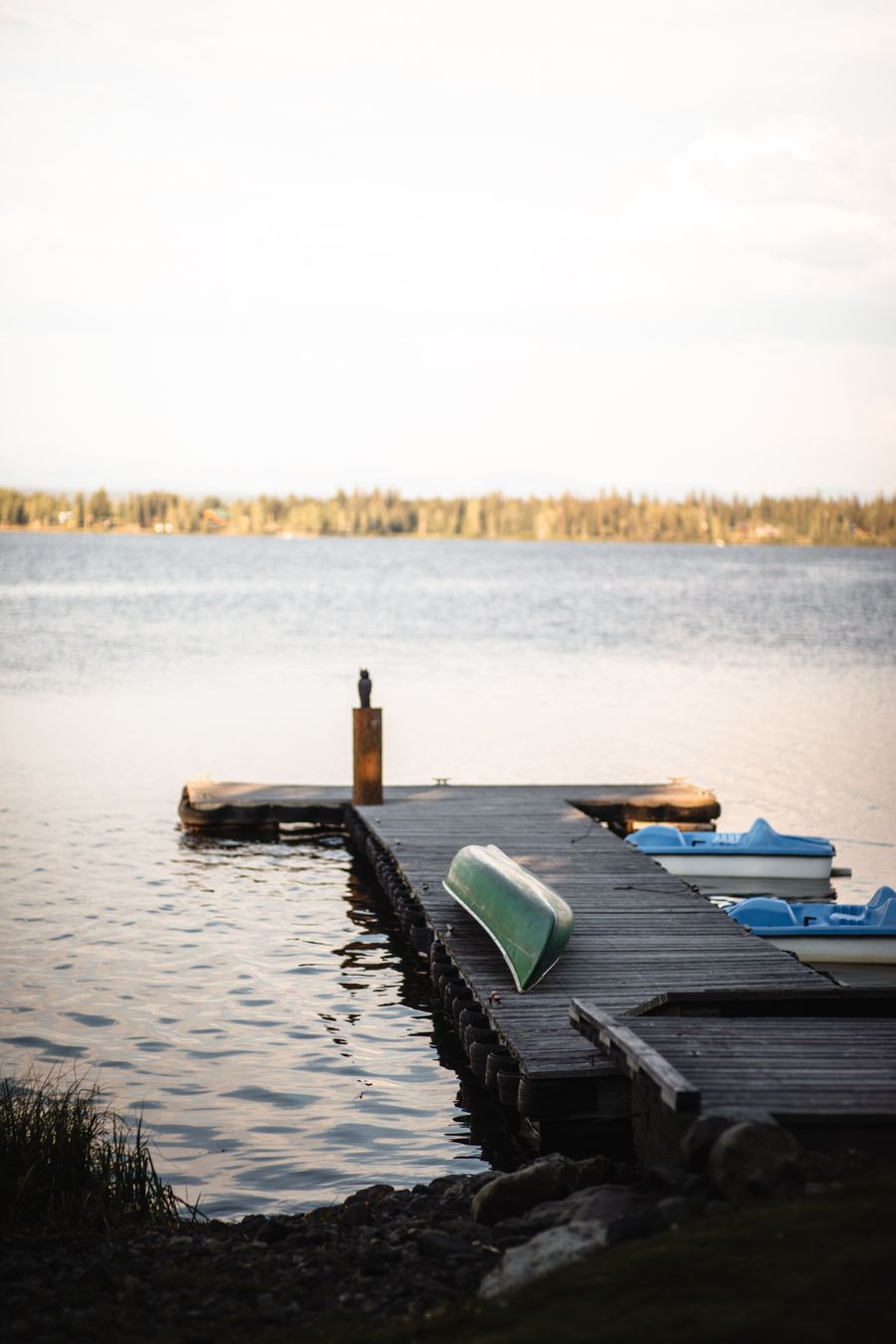 The dock on Anahim Lake with an upturned green canoe and pedal boats